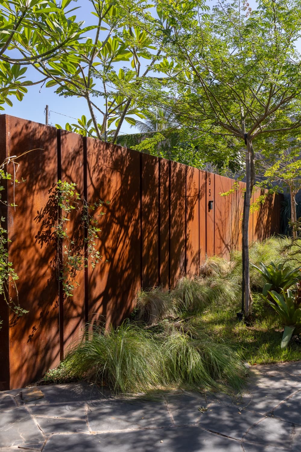 Obra em aço corten: Cerca integrada ao paisagismo, executada pela Alupoli